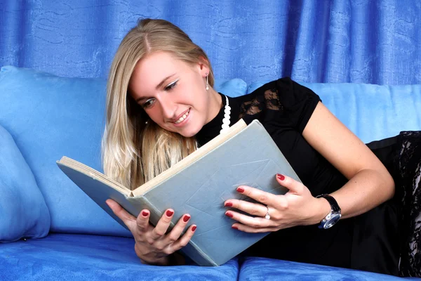 Γυναίκα που Διαβάστε το βιβλίο στο σπίτι σε καναπέ — Φωτογραφία Αρχείου