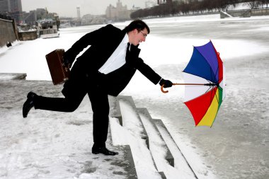Businessman with umbrella in city clipart