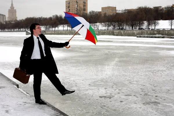 Бизнесмен с зонтиком в зимнем городе — стоковое фото