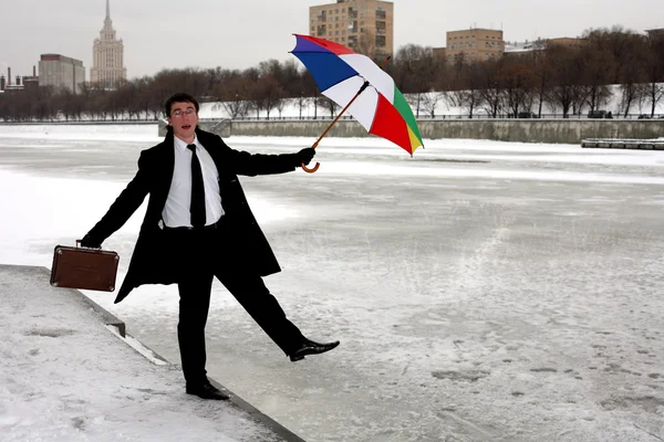 Businessman with umbrella in winter city