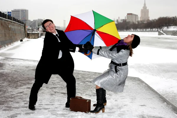 Girl and man fighting with umbrella — Stock Photo, Image