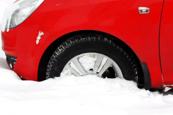 Rueda cubierta de nieve coche en la ciudad — Foto de Stock
