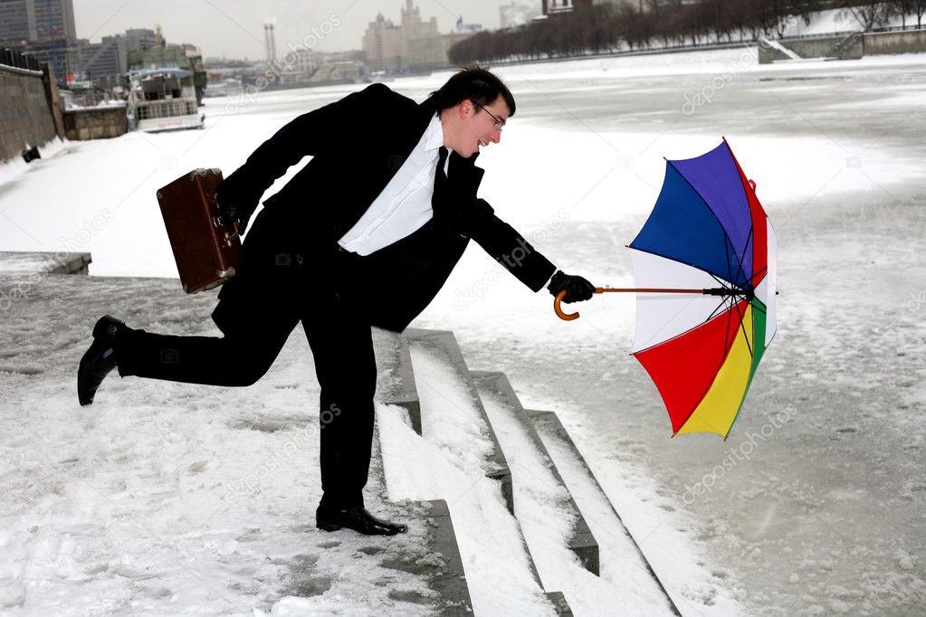 Businessman with umbrella in city