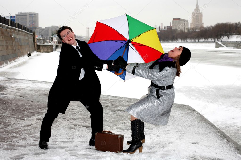 Girl and man fighting with umbrella