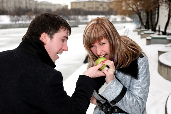 Girl and man outdoors with apple — Stock Photo, Image