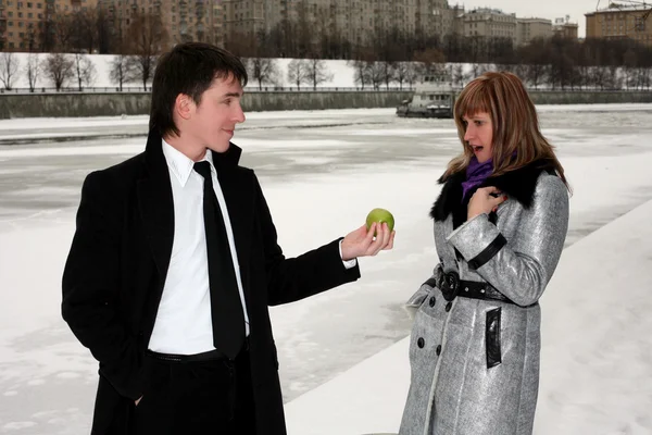 Flickan och mannen utomhus med äpple — Stockfoto