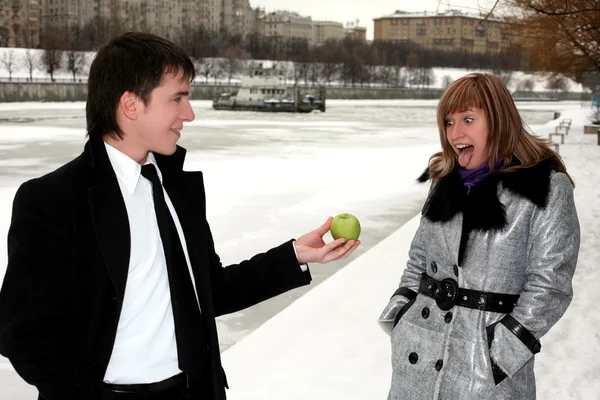 Girl and man outdoors with apple — Stock Photo, Image