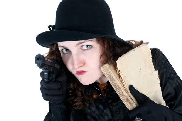 Flicka i hatt med gammal bok och pistol — Stockfoto