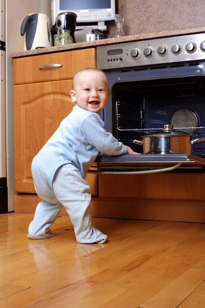 Funny baby cooking at stove — Stock Photo, Image
