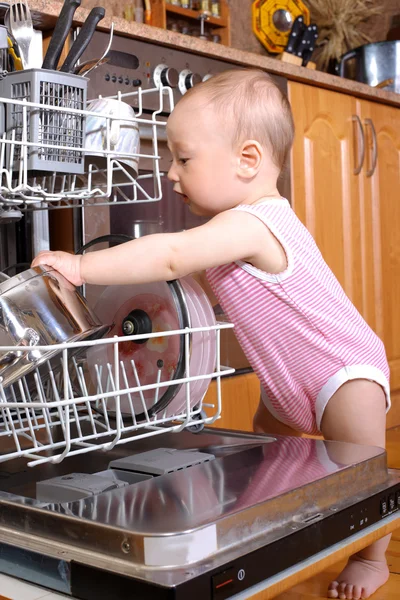 Ребенок за посудой на кухне — стоковое фото