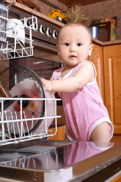 Baby at dishwasher in kitchen — Stock Photo, Image