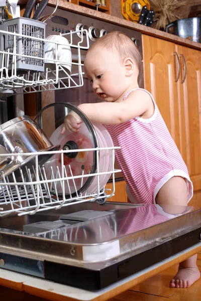 Baby at dishwasher in kitchen — Stock Photo, Image