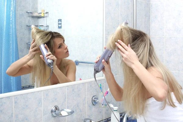 Žena v koupelně na zrcadlo sušení vlasů — Stock fotografie