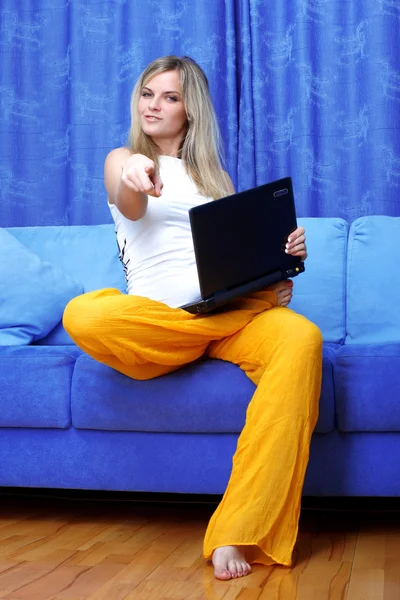 Женщина, работающая с компьютером дома на диване — стоковое фото