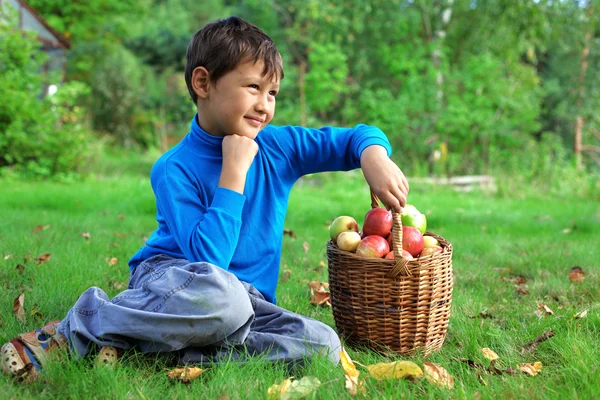Συγκομιδή χρόνος - μικρό αγόρι που θέτουν σε εξωτερικούς χώρους με μήλα — Φωτογραφία Αρχείου