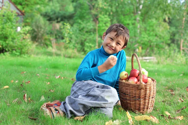 Menino posando ao ar livre com maçãs — Fotografia de Stock