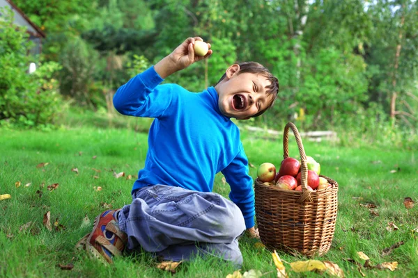 Nagy termés - kisfiú jelentő szabadban almával — Stock Fotó
