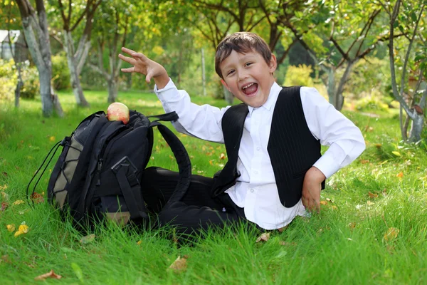 Skolpojke med ryggsäck och apple utomhus — Stockfoto