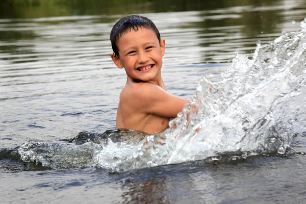Junge im Fluss mit Spritzwasser — Stockfoto