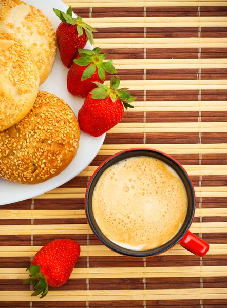 Kaffee, Brötchen und Erdbeeren auf dem Tisch — Stockfoto