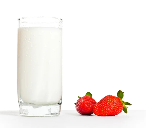 Glass of milk and two strawberries — Stock Photo, Image