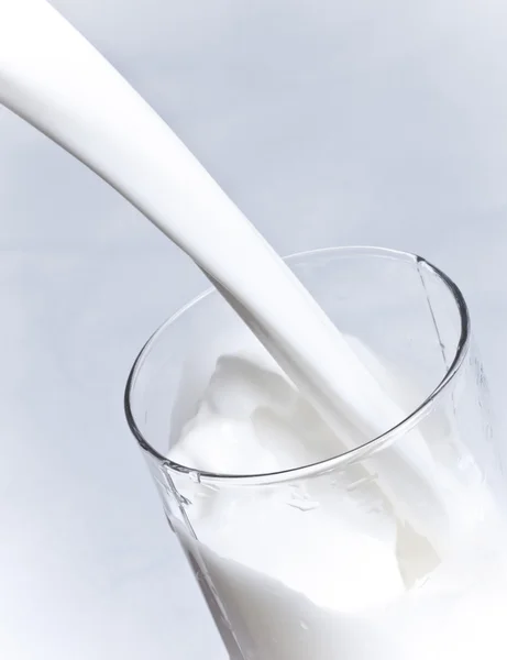 Το γάλα χύνεται σε ένα ποτήρι — Φωτογραφία Αρχείου
