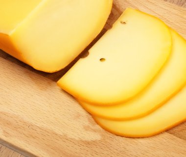 Cheese slices on cutting board clipart
