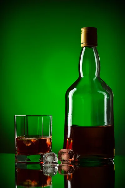 Whiskey bottle, ice and glass — Stock Photo, Image
