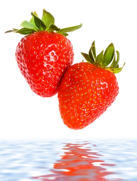 Färska mogna jordgubbar falla i vatten — Stockfoto