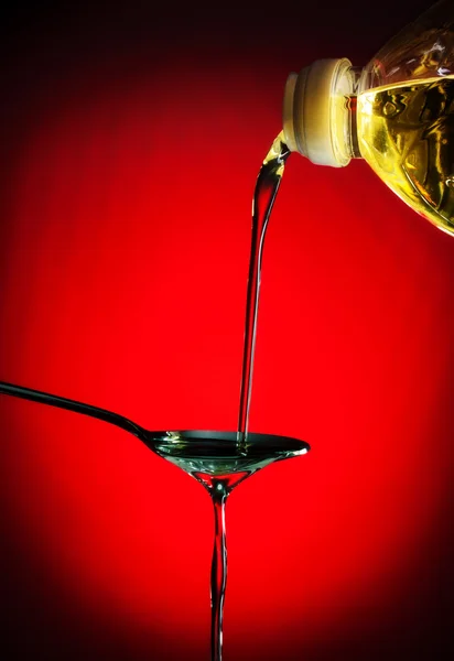 Pouring oil on spoon — Stock Photo, Image