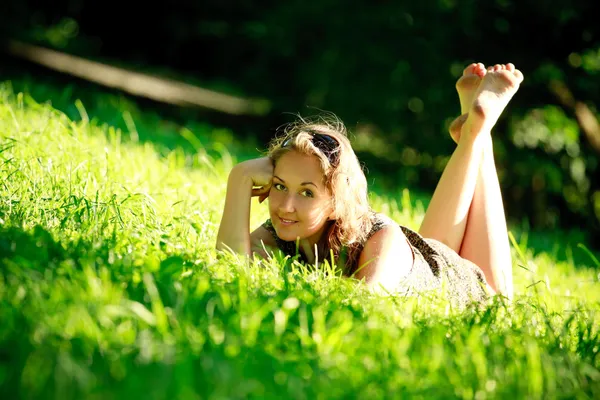 Güzel kız güneşli çayır üzerinde döşeme — Stok fotoğraf
