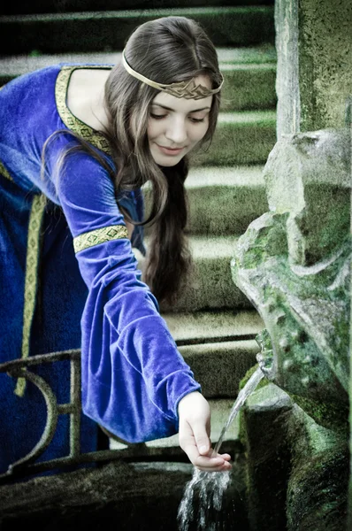 Medieval girl next ancient spring — Stock Photo, Image