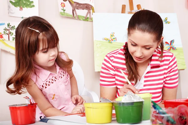 Ребенок с учителем рисует краски — стоковое фото