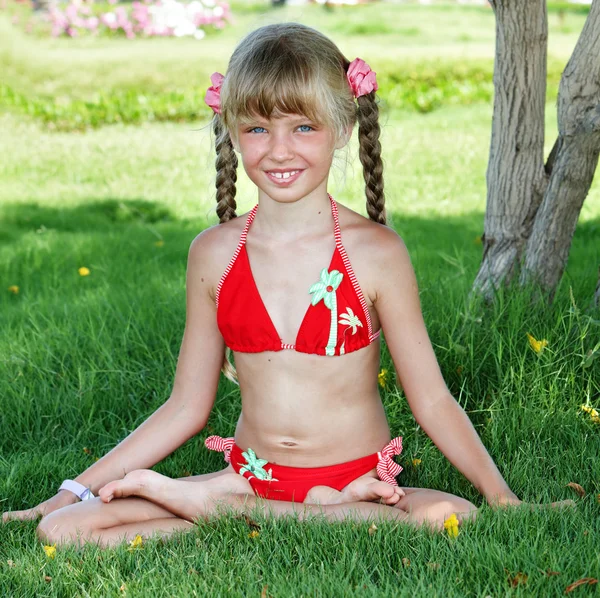 Küçük kız lotus pozisyonda oturmak ve meditasyon. — Stok fotoğraf