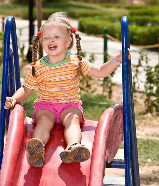 Niño en la diapositiva en el parque de playground.Outdoor . — Foto de Stock