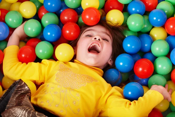 Счастливая маленькая девочка в группе красочный мяч . — стоковое фото