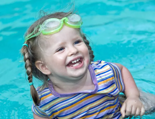 Щаслива маленька дівчинка дивиться з басейну — стокове фото