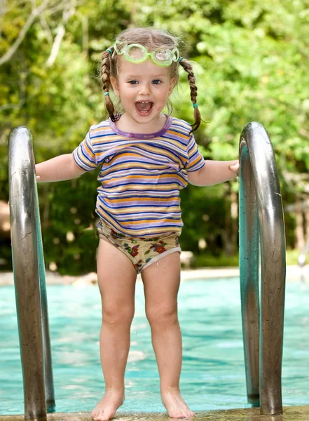 Baby in beschermende bril bladeren zwembad. — Stockfoto
