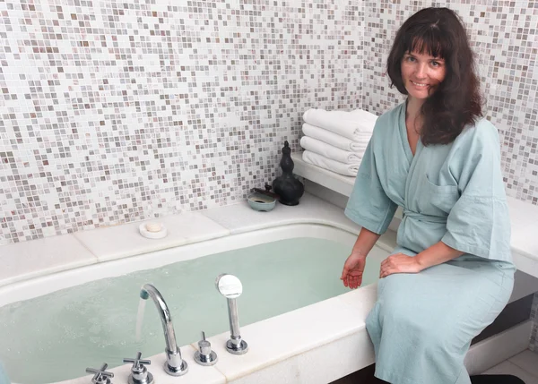 Young woman wearing bathrobe in bathroom. — Stock Photo, Image
