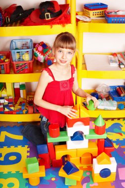 Child with block and construction set in play room. Preschool. clipart