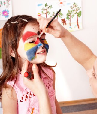 Child preschooler with face painting. clipart