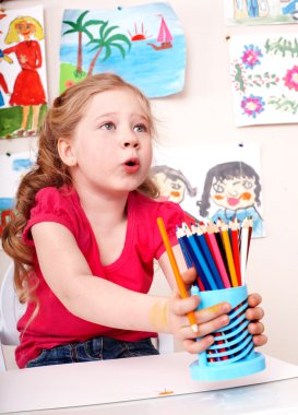 Child with pencil in play room. clipart