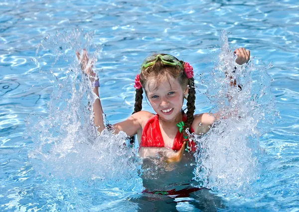 Meisje met rode zwembroek spetteren in zwembad. — Stockfoto