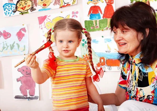 Dítě s učitelem kreslení barvy v herně. školka. — Stock fotografie