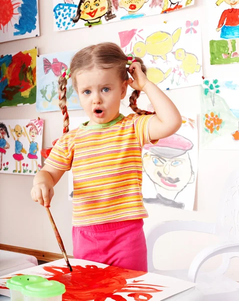 Ребенок с картинкой и кистью в игровой комнате . — стоковое фото