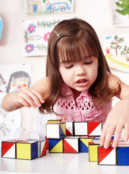 Kind met blok hout en bouw instellen in de speelkamer. — Stockfoto