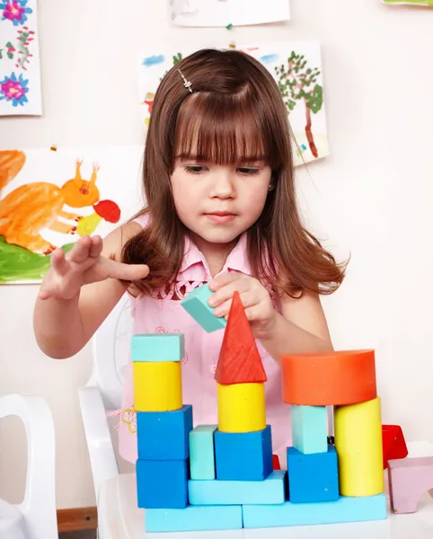 Bambino con blocco di legno e set di costruzione in sala giochi . — Foto Stock