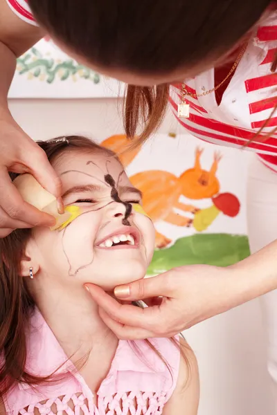 Kind met verf van gezicht in de speelkamer. — Stockfoto