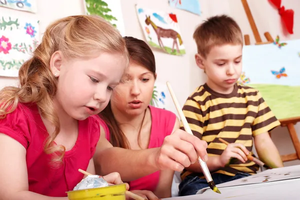 Children painting with teacher. — Stock Photo, Image