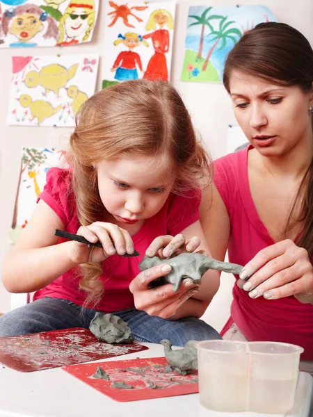 Child girl mould from clay in play room. — Stock Photo, Image